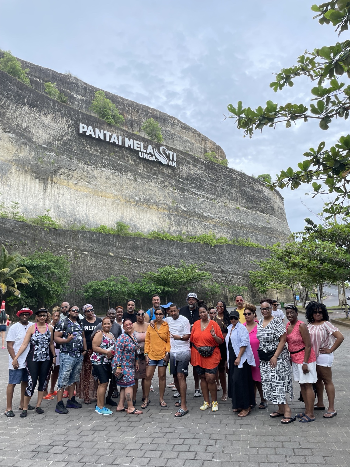 A large travel group smiling together during an island excursion