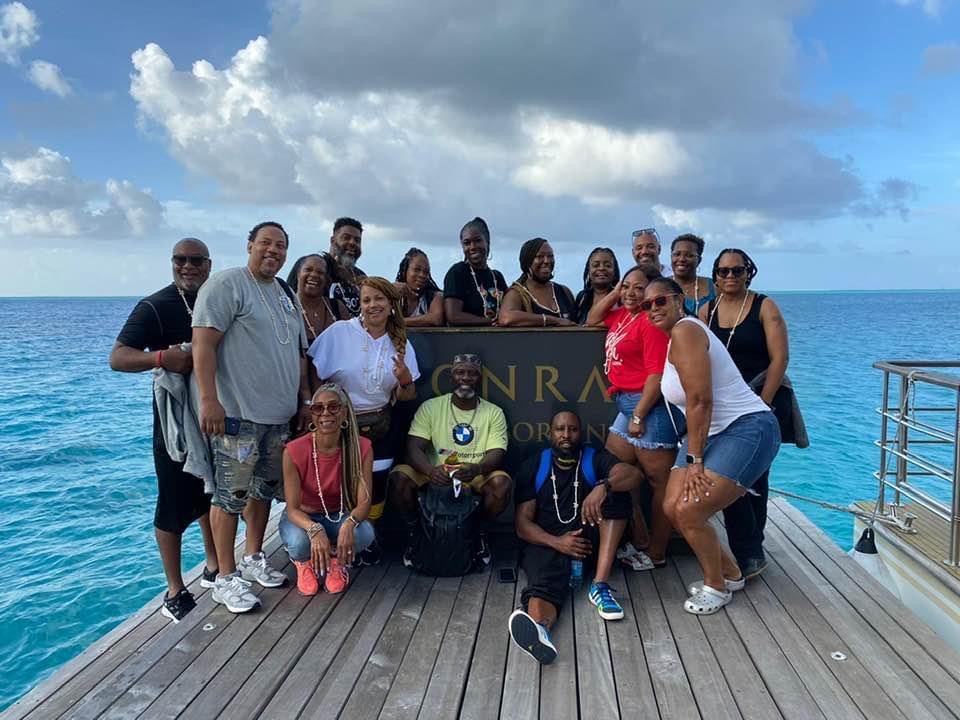 Travelers posing together beside bright blue ocean water